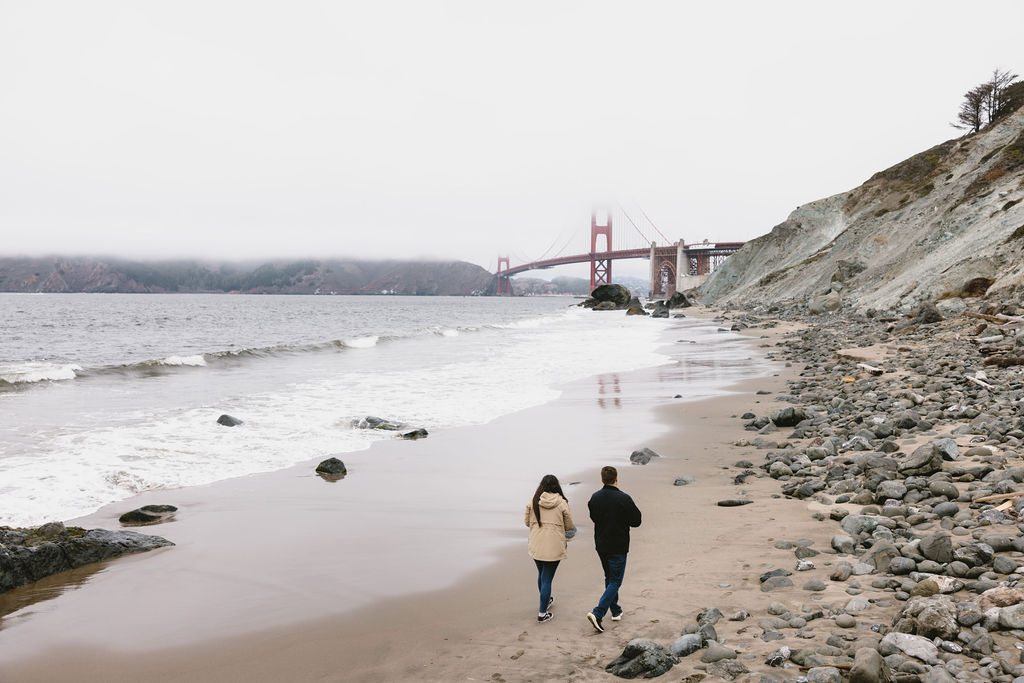 Couple walking Bakers Beach in San Francisco California 