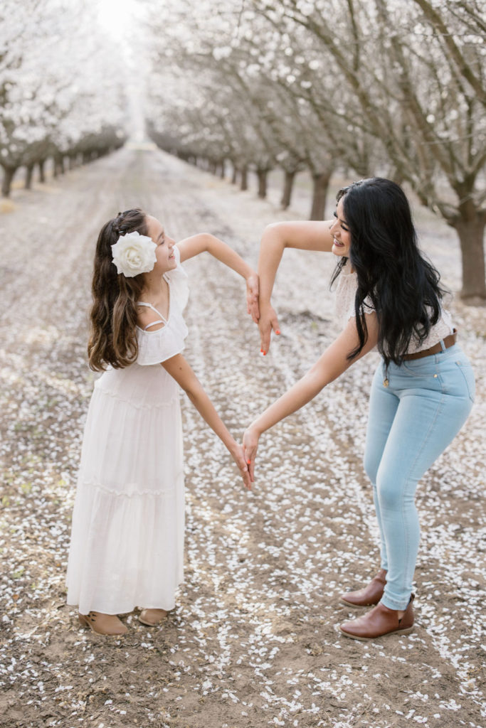 Mother and daughter posing with almond blooms