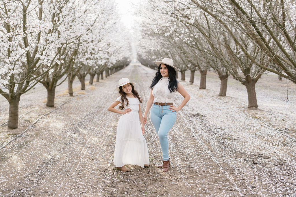 mother and daughter posing for photos in the orchard