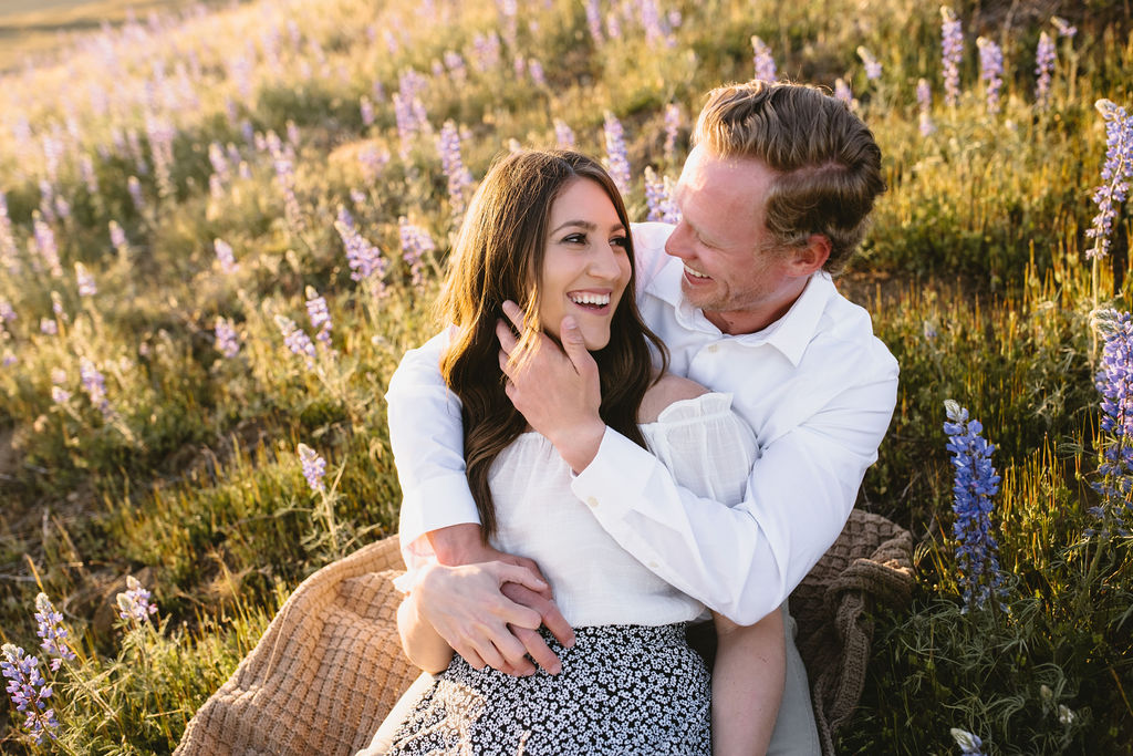 Couple sitting in a wilfflower field during photoshoot in Fresno California