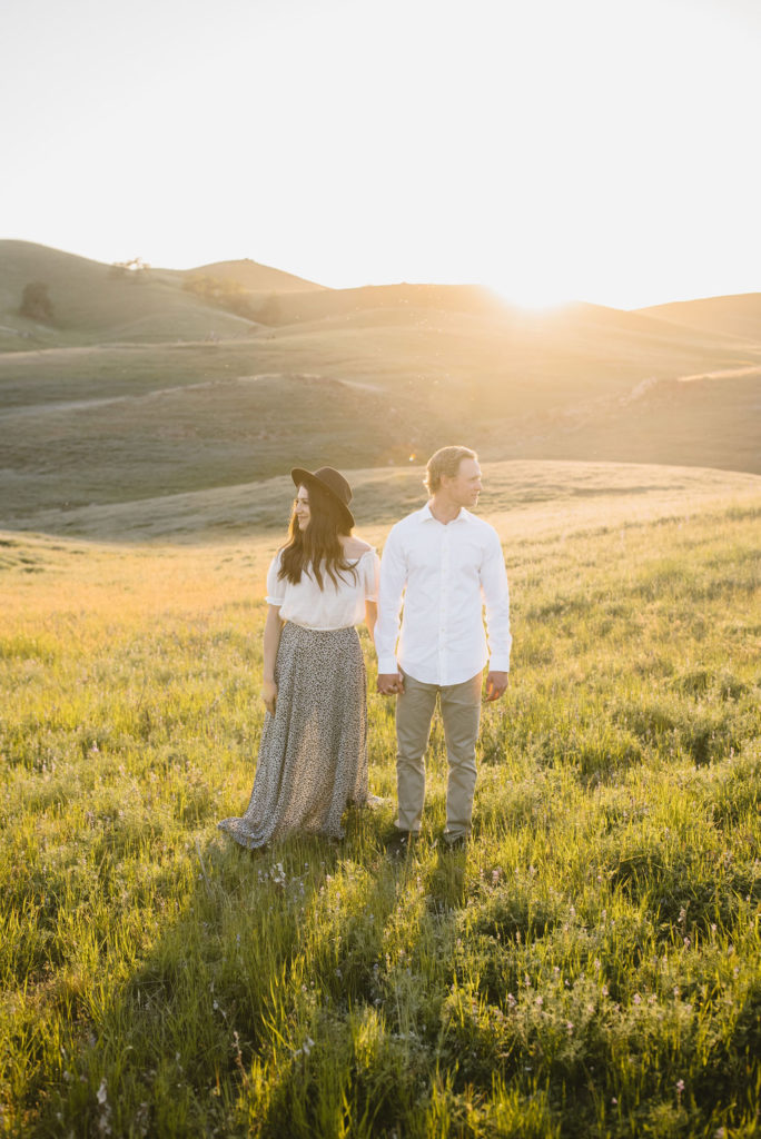 Man and women posing for engagement session photos in a California valley