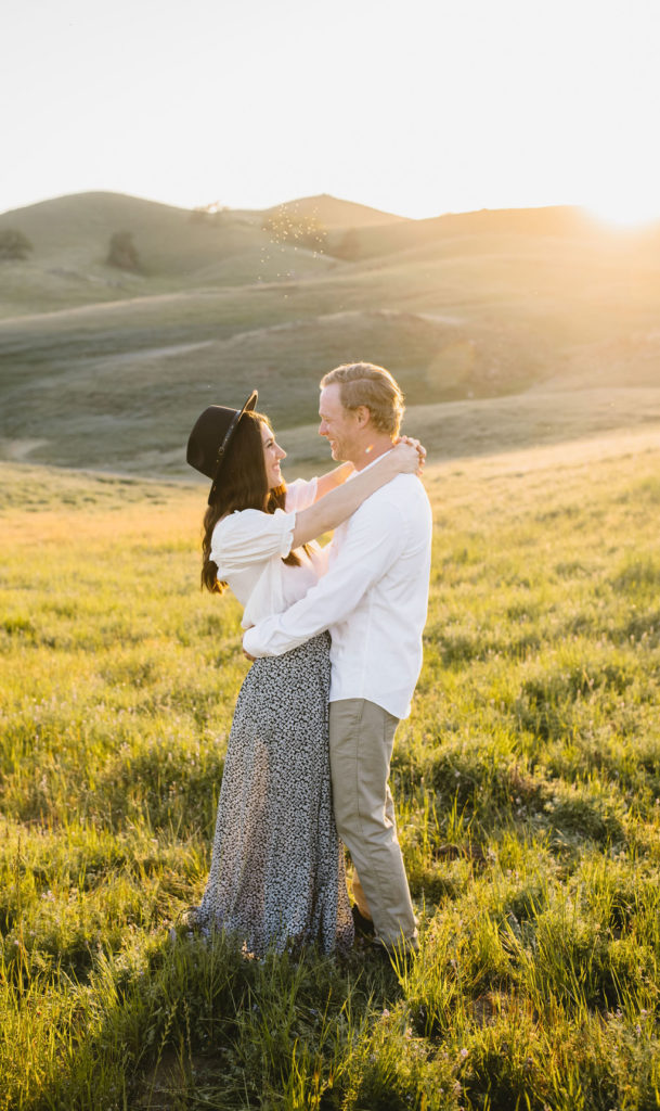 A romantic engagement session with wildflowers on a hilside in Fresno California
