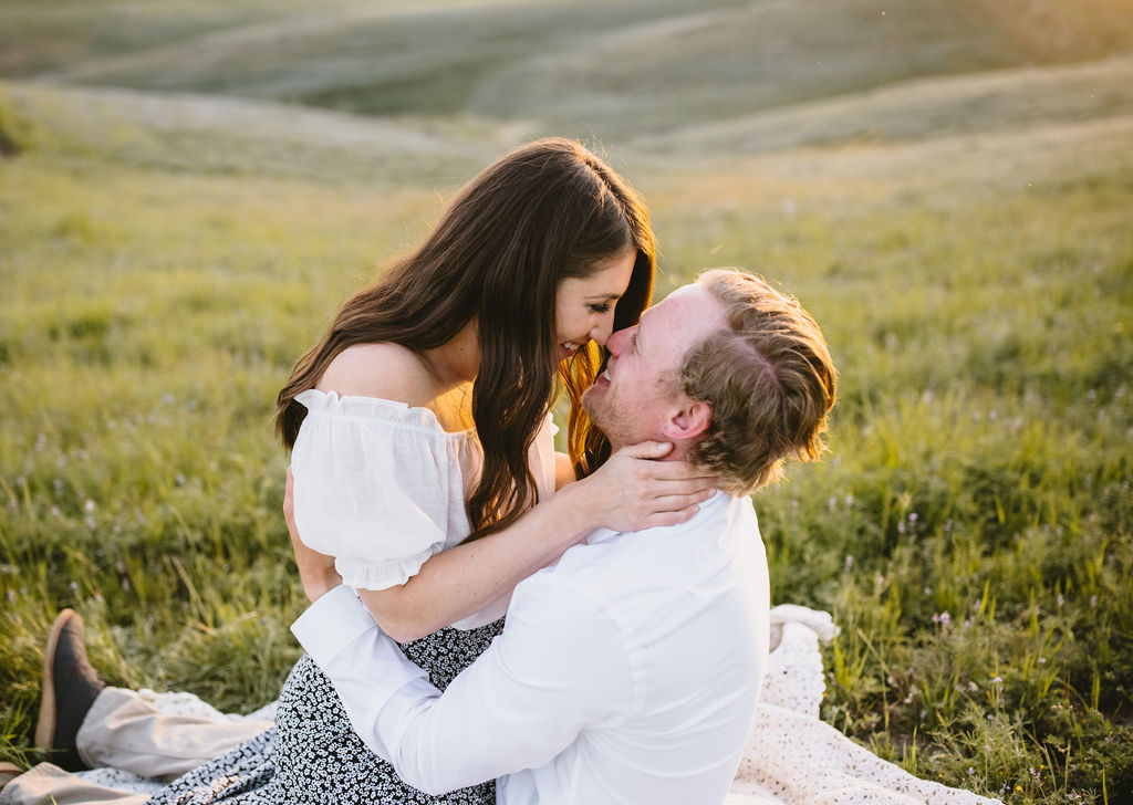 Women sitting on mans lap during engagement session