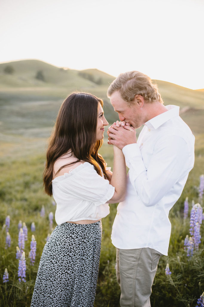 Man kissing womens hands during wildflower photoshoot