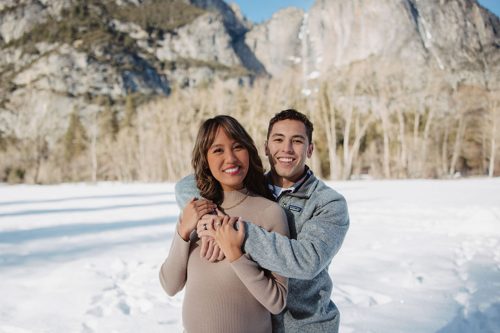 Couple posing for maternity photos during the winter in Yosemite National Park