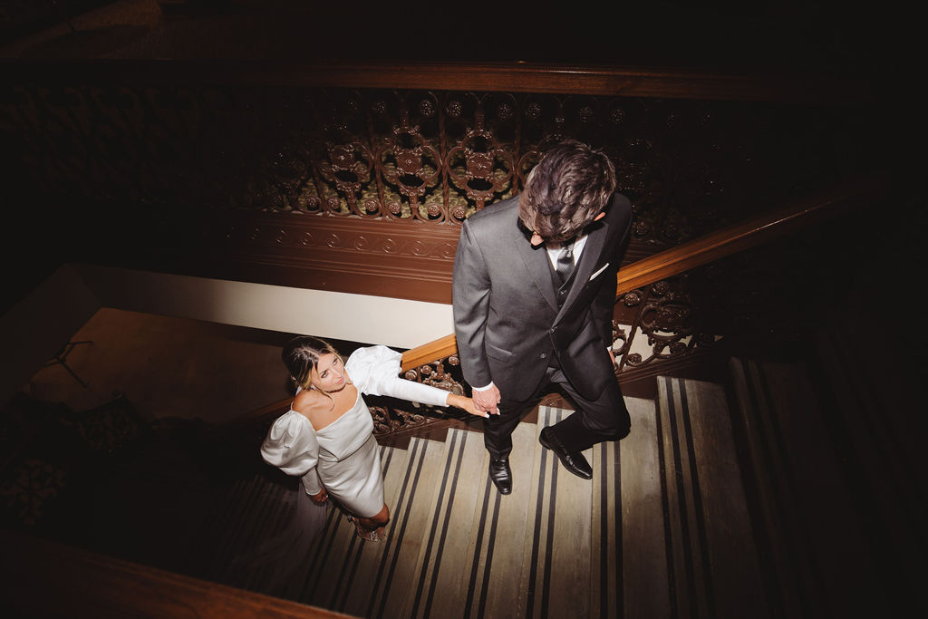 Bride and groom walking up stairs at The Grand 1401 in Fresno, CA by wedding photographer in Fresno, CA - Alyssa Michele Photo