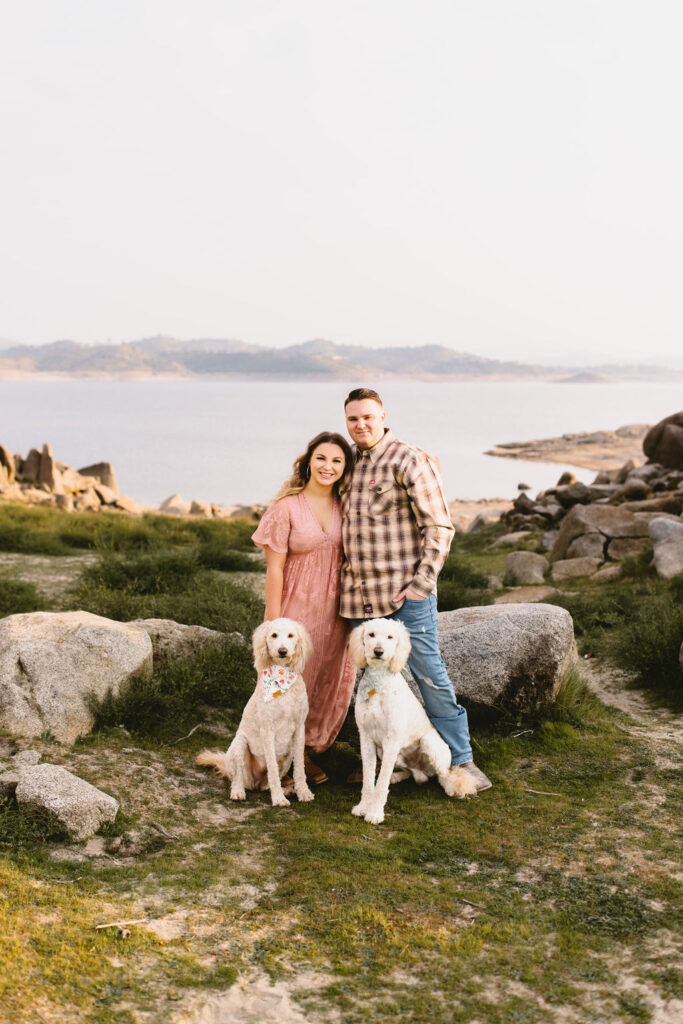 Couple posing for engagement photos with two dogs in California