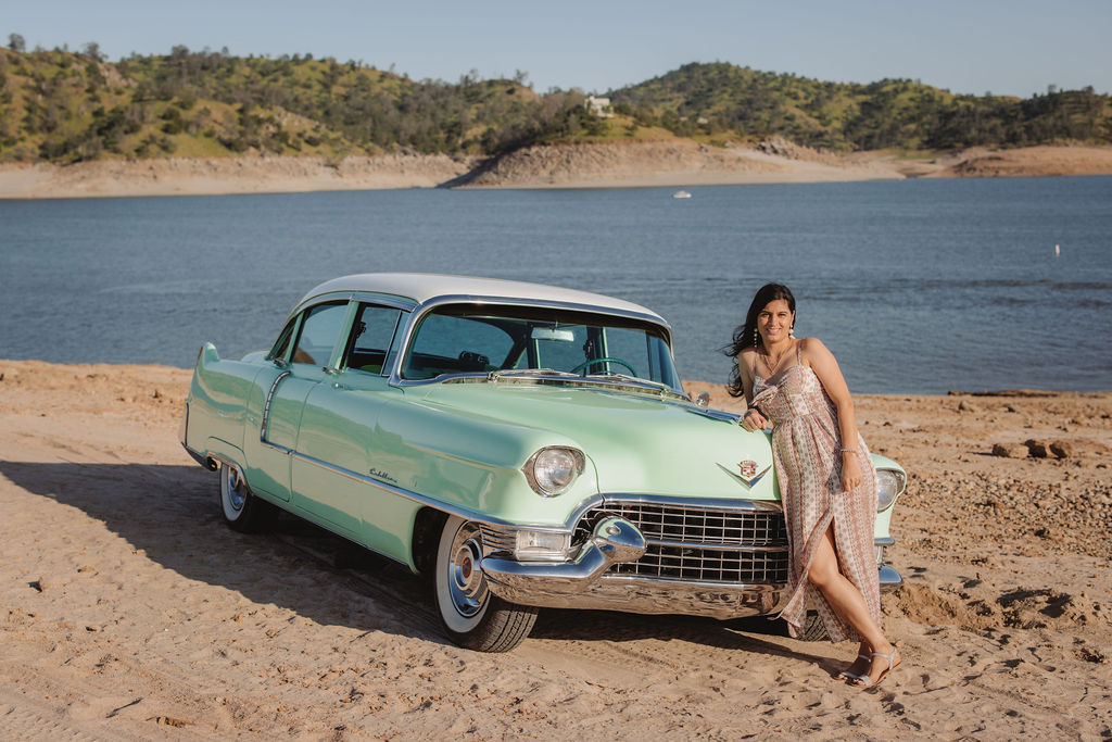 Women posing next to a vintage car