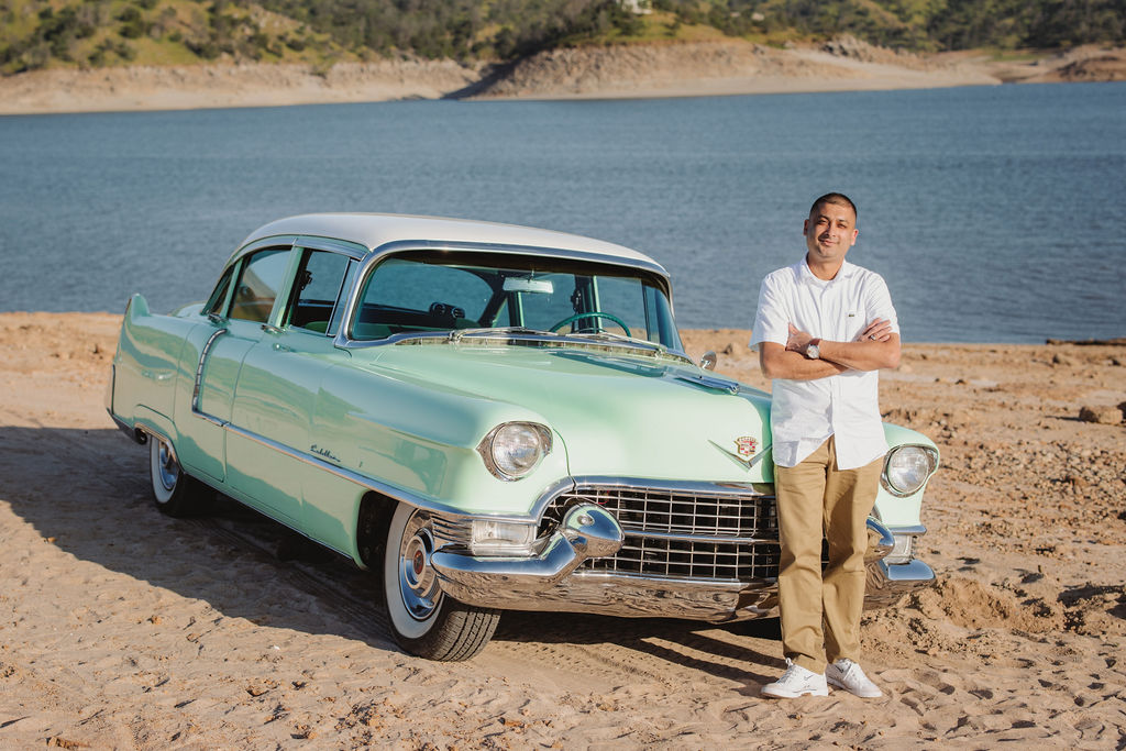 Man posing next to a vintage car