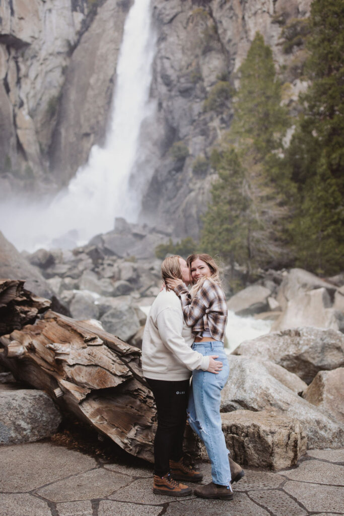 lesiban couple kissing in front of waterfall