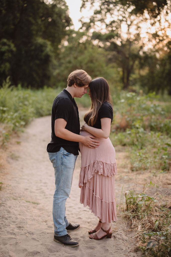Couple posing for outdoor photoshoot during pregnancy
