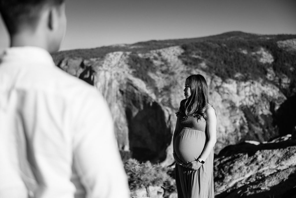 Couple posing for maternity session at Taft Point in Yosemite