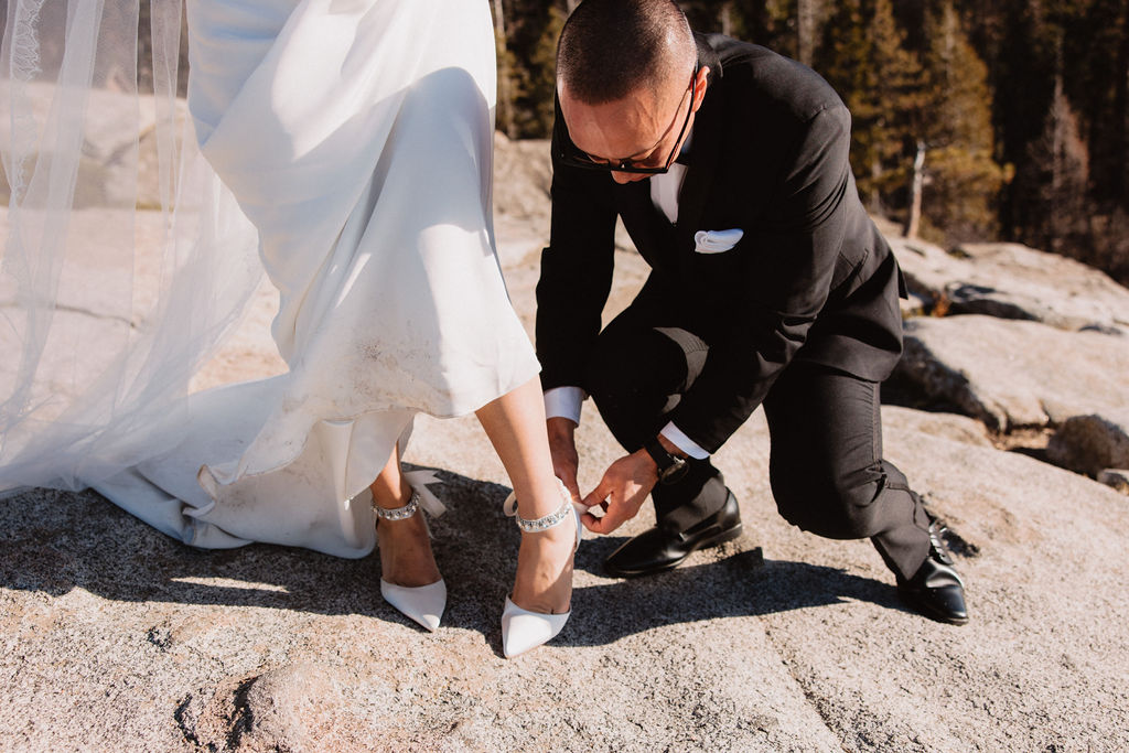 Groom fixing brides shoes