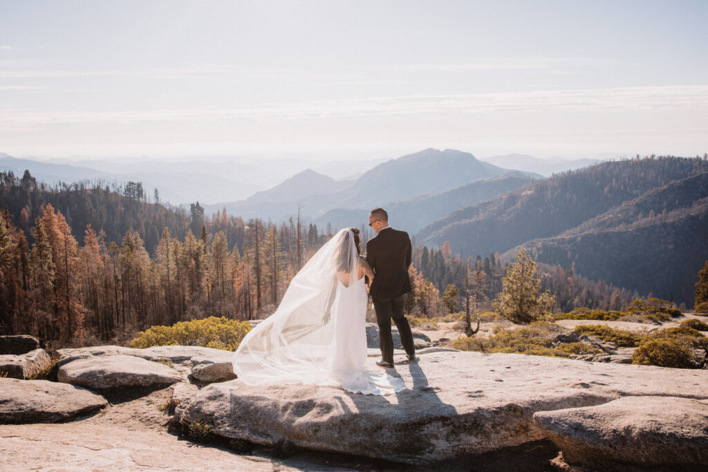 Bride and groom looking out into the distance at beetle rock in sequoia national park after their elopement ceremony