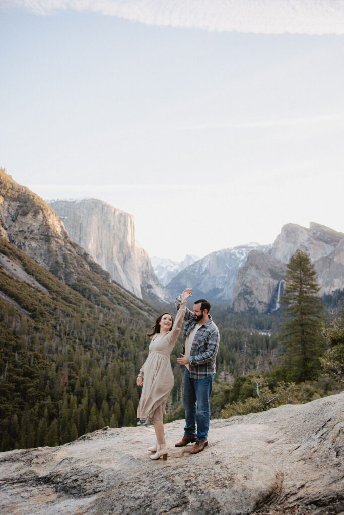 Man and woman posing for photos at Tunnel View
