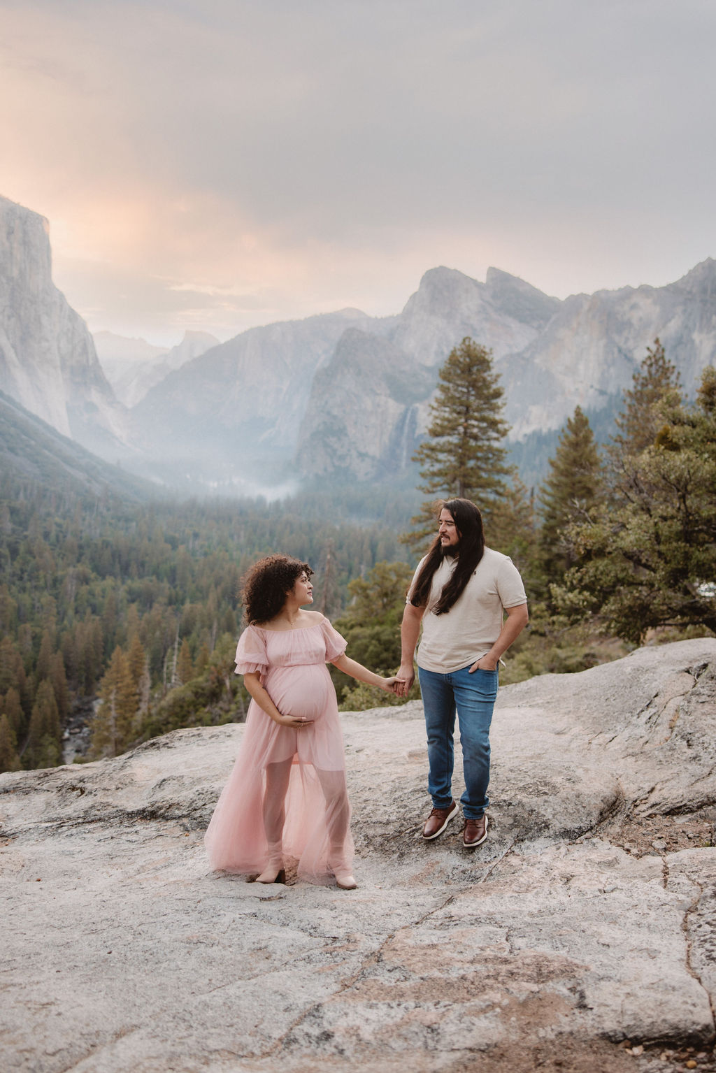 Couple holding hands in Yosemite for their maternity photos at sunrise