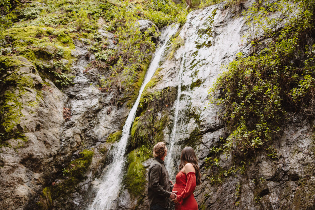 couple looking at waterfall in big sur