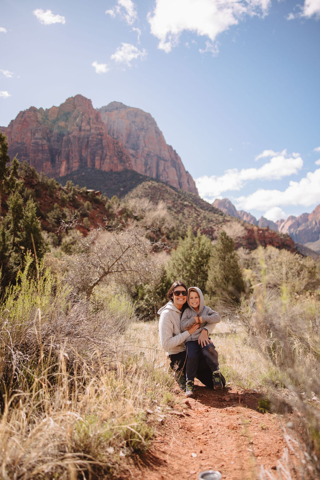 A family standing on a road with a scenic mountain backdrop in zion national park.
