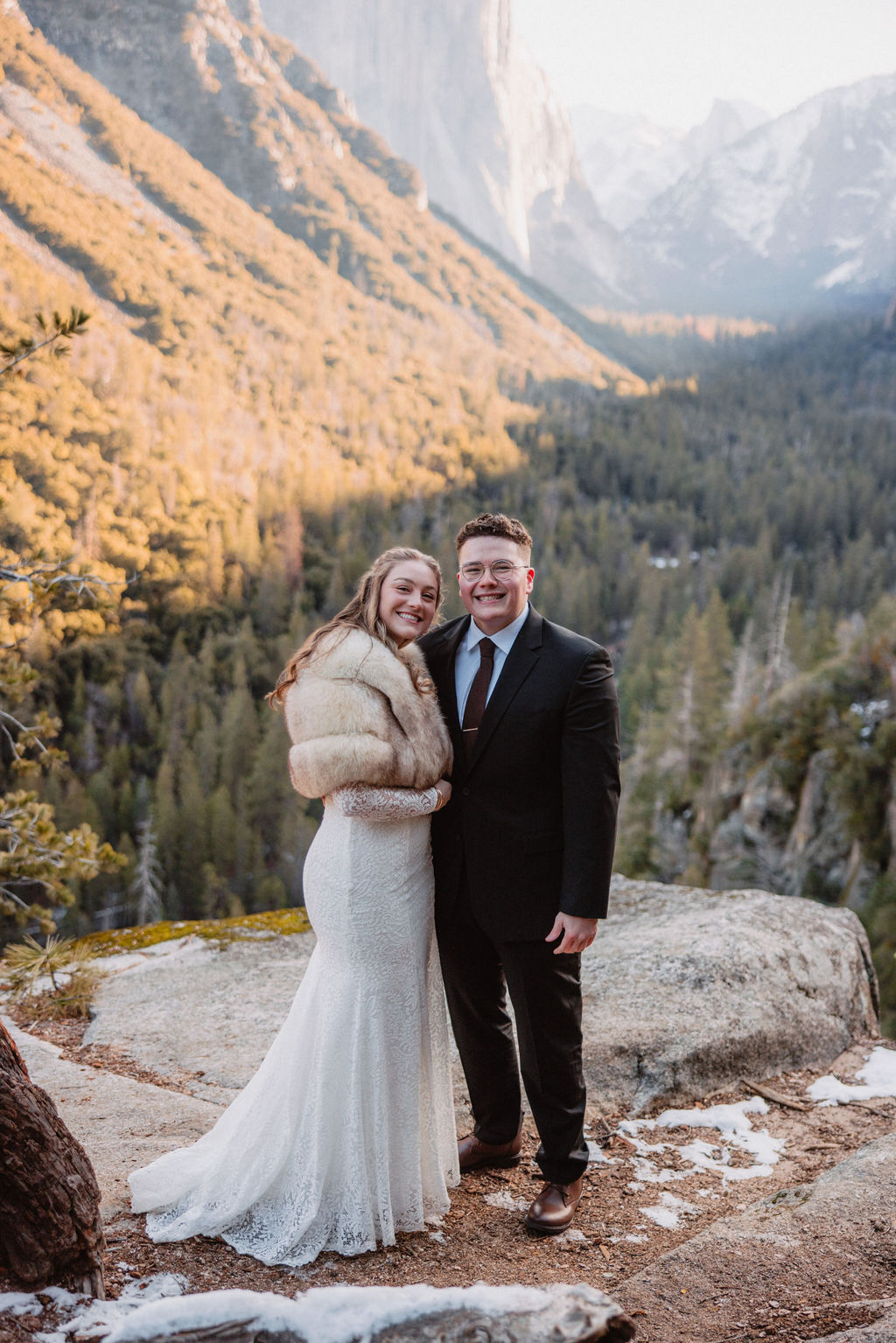 A couple embracing and smiling at  their elopement in a mountainous backdrop bathed in golden sunlight for their yosemite national park elopement 