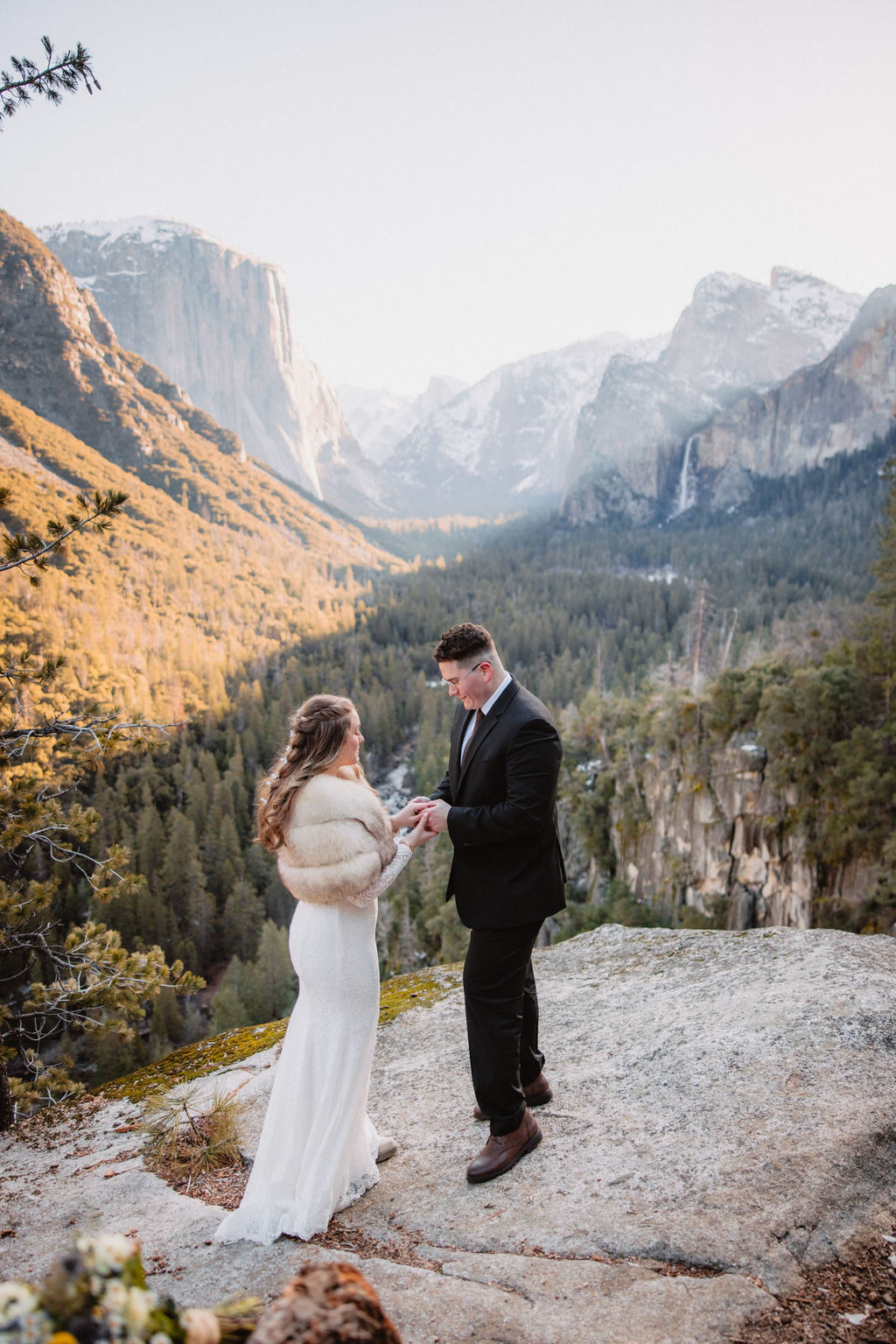 A couple embracing and smiling at each other at their elopement in a mountainous backdrop bathed in golden sunlight for their yosemite national park elopement 