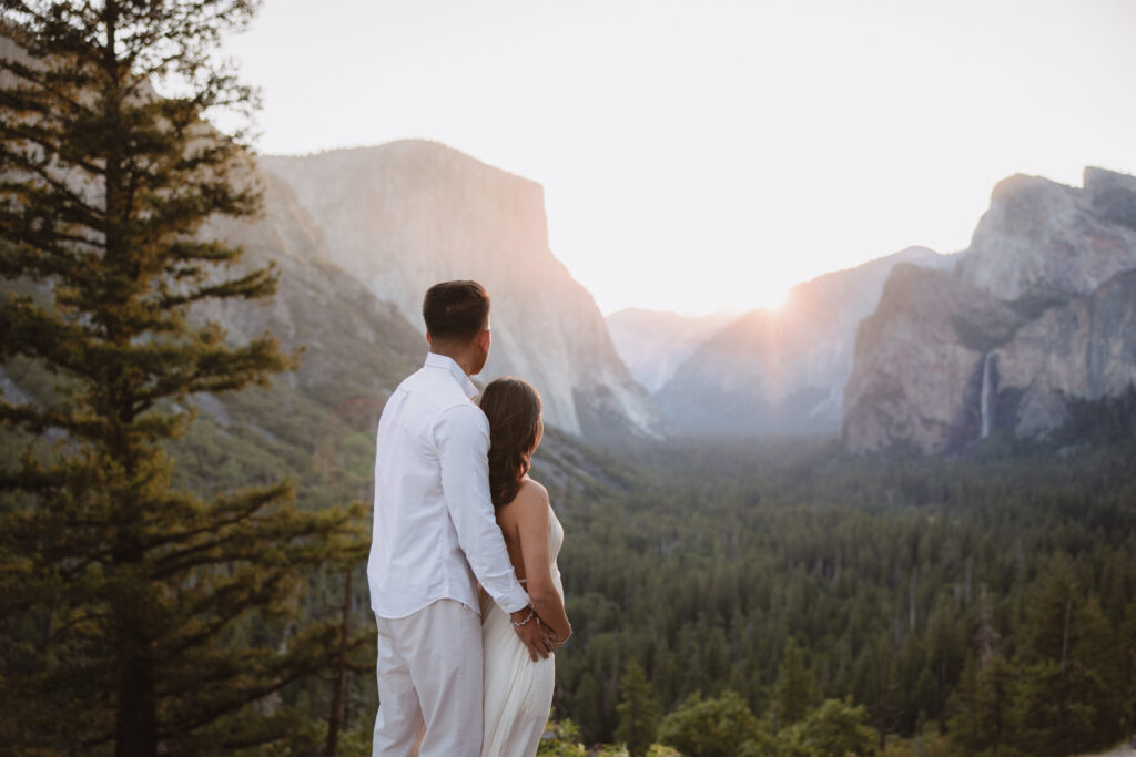 Couple watching the sunrise at tunnel view in yosemite during their maternity photoshoot. 