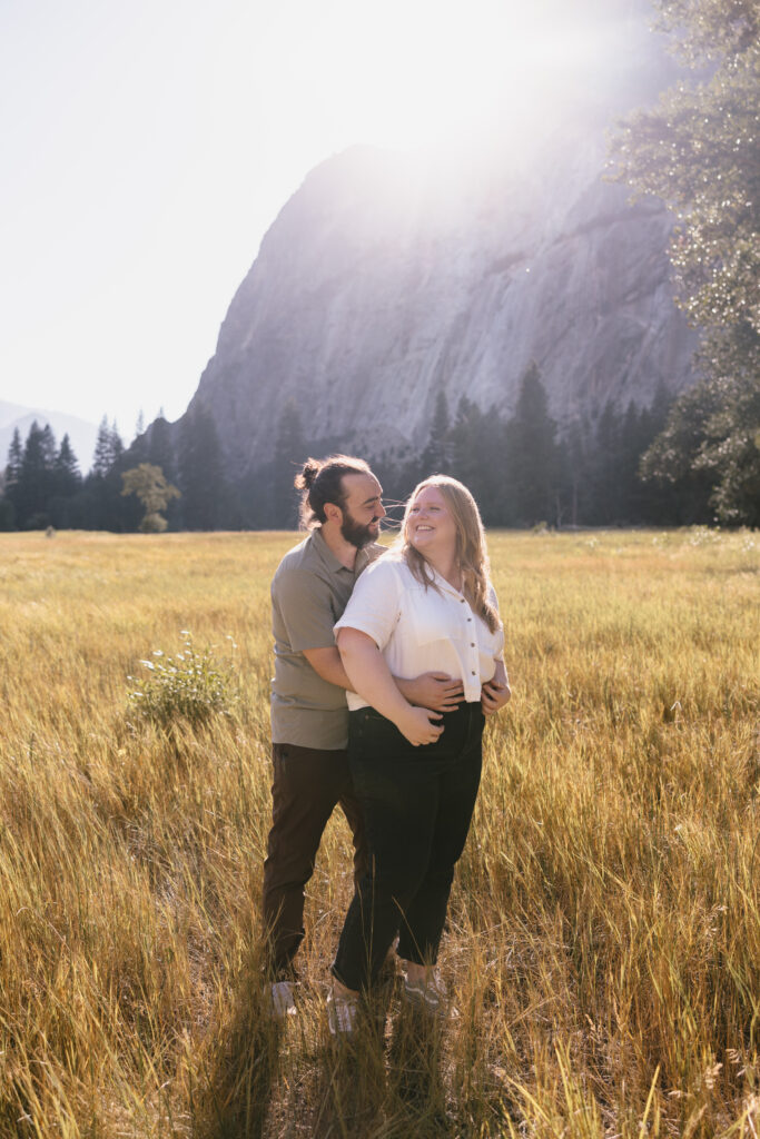 Couple holding each other at cooks meadow in yosemite during sunset. 