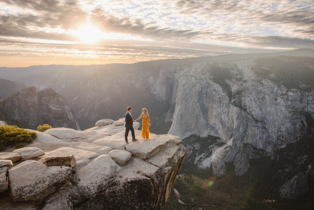 Taft point engagement photoshoot with El Cap in the background. Couple sitting on rock looking out in the distance.