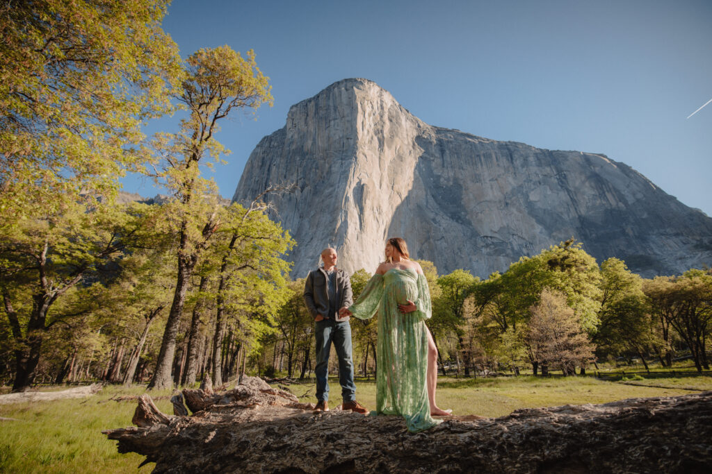 Maternity couple walking on a log with el Capitan in the background in yosemite. 