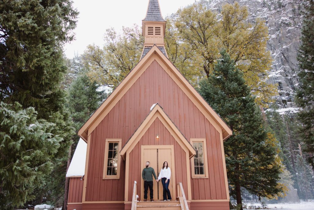 Couple posing during their engagement photoshoot in front of yosemite chapel. 