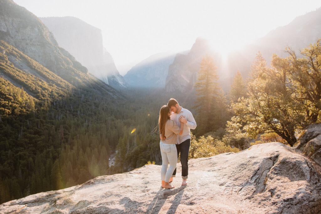 Couple dancing on a rock at tunnel view in yosemite at sunrise during their engagement photoshoot. 