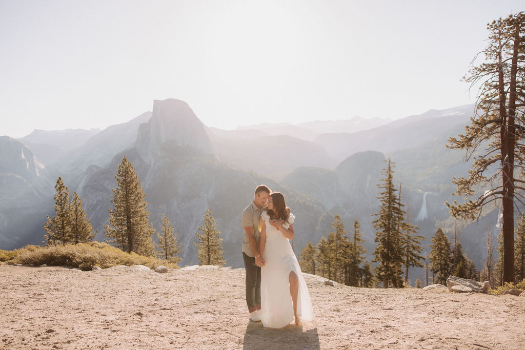 Couple posing with half dome in the background.