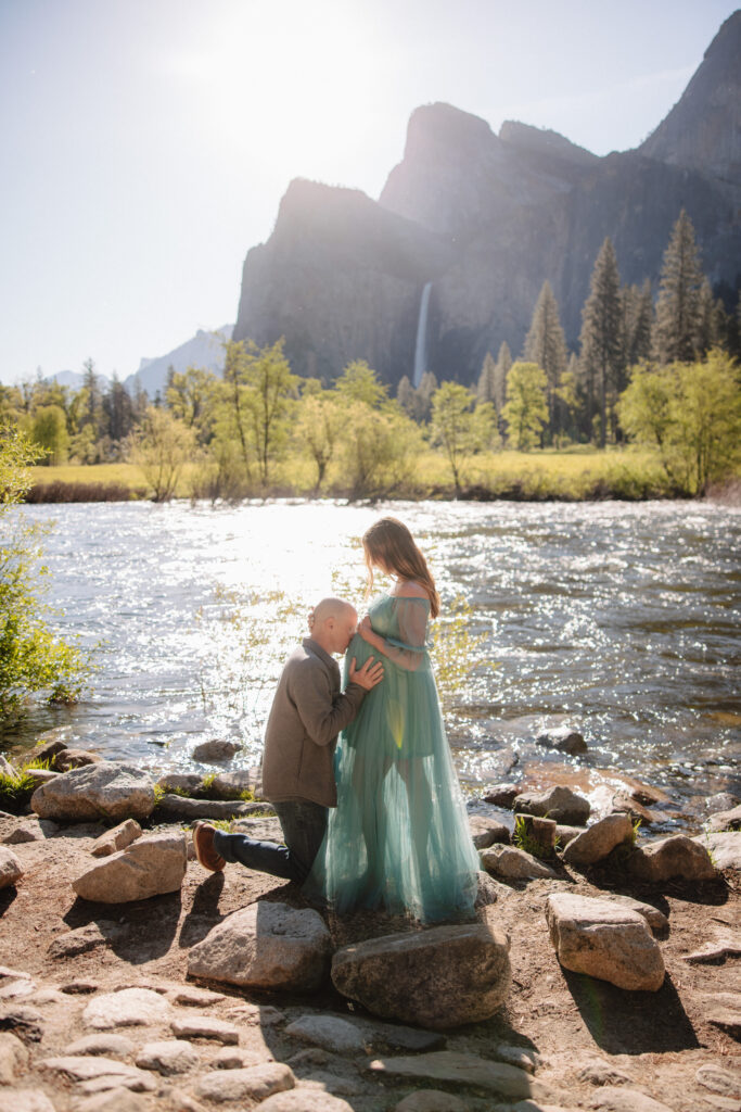Man kissing woman's stomach during their engagement photoshoot at valley view in yosemite. 