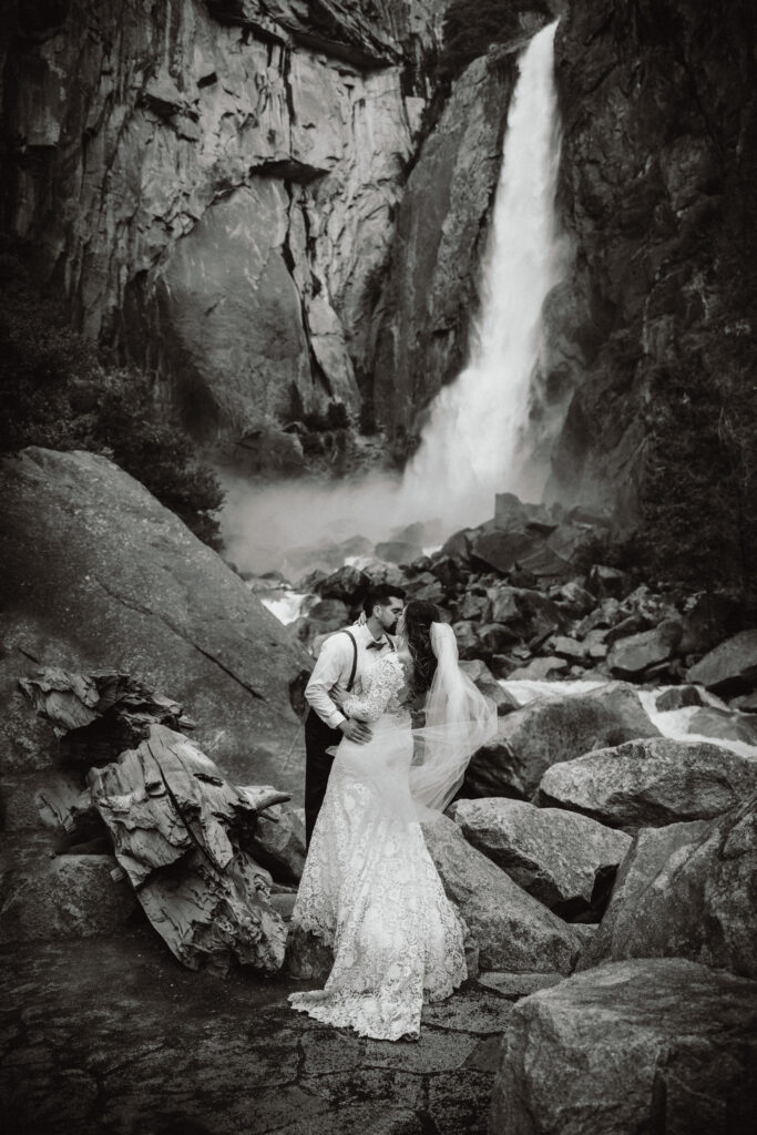Bride and groom kissing at yosemite falls during their elopement in the spring. 