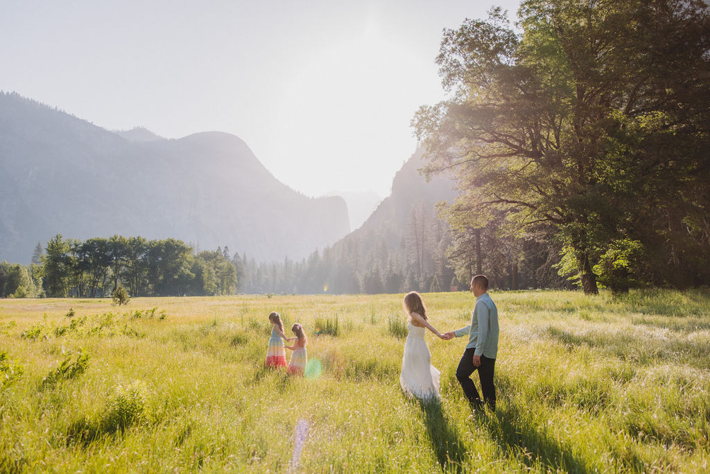 Family at Yosemite National park for their documentary style family photos walking into meadow