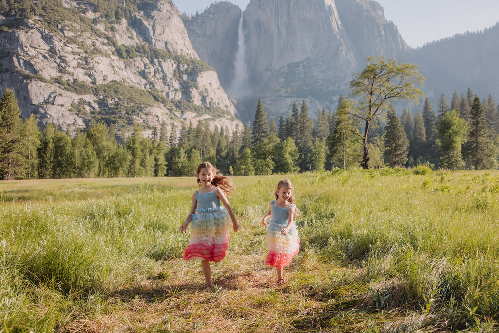 Family at Yosemite National park for their documentary style family photos walking into meadow and children running around