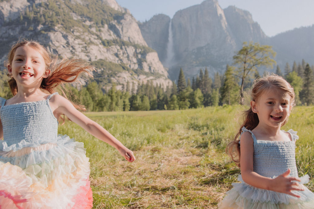 Family at Yosemite National park for their documentary style family photos walking into meadow and children running around