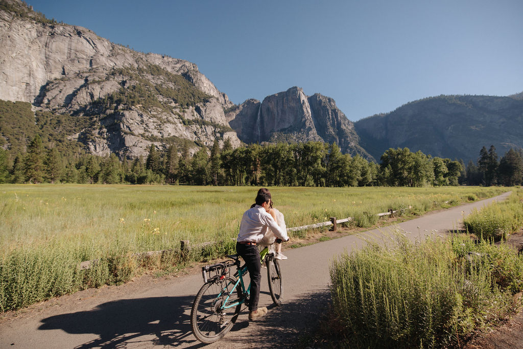 couple rides bike at yosemite falls for their yosemite elopement photos