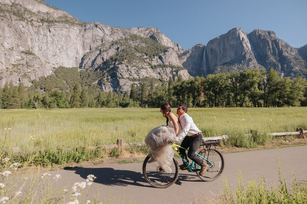 couple rides bike at yosemite falls for their yosemite elopement photos