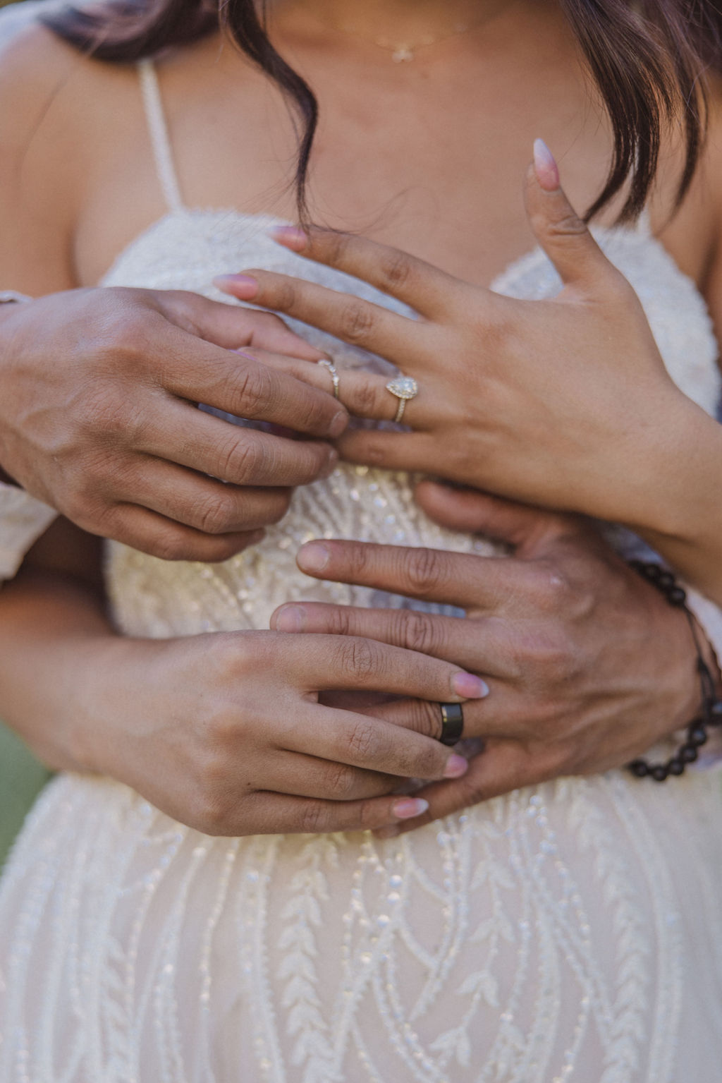 A couple stands in a meadow with a mountainous landscape in the background. The bride is twirling in her dress while the groom looks on at Yosemite elopement photos