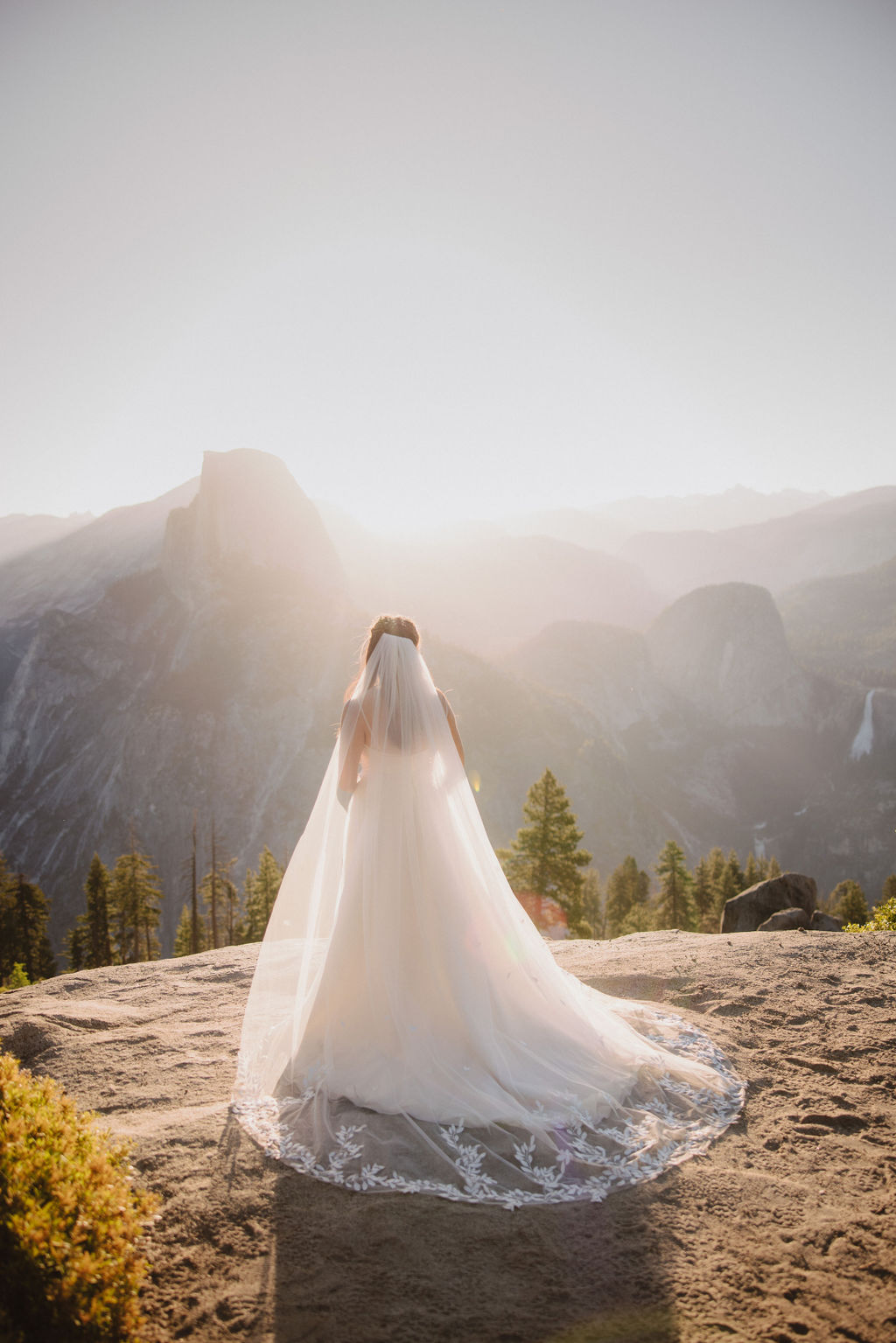 Bride and Groom at their Yosemite elopement on a ledge ith a beautiful sunset 