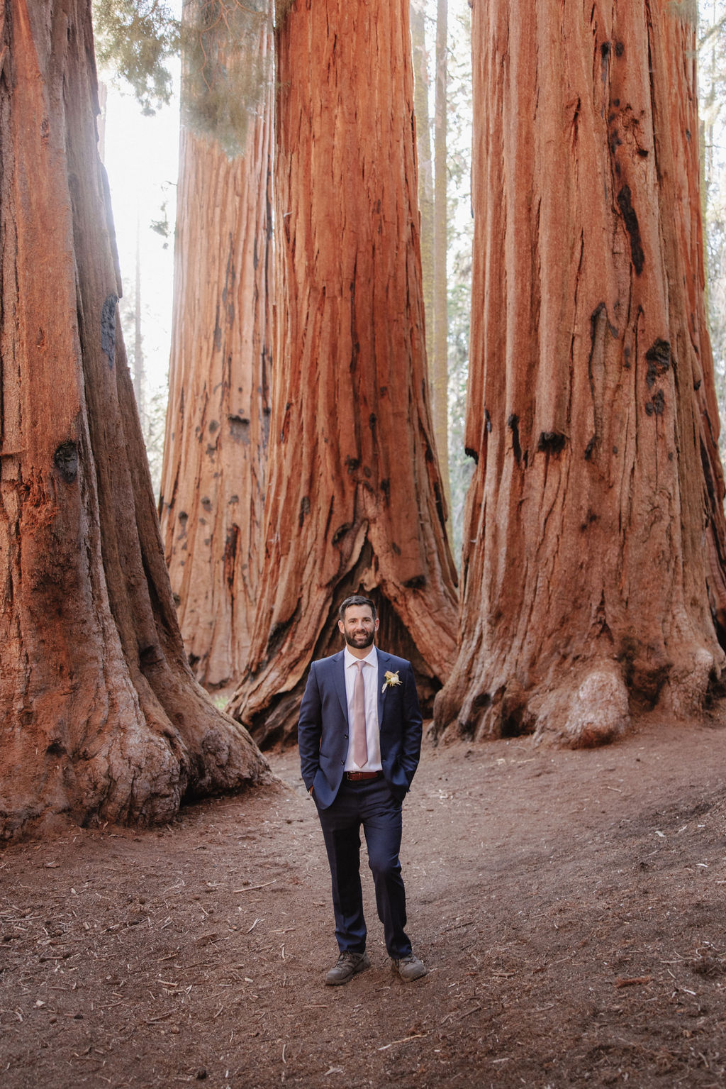 A bride in a white gown holds a bouquet while standing in front of large redwood trees 
Top 5 reasons to elope in sequoia national park