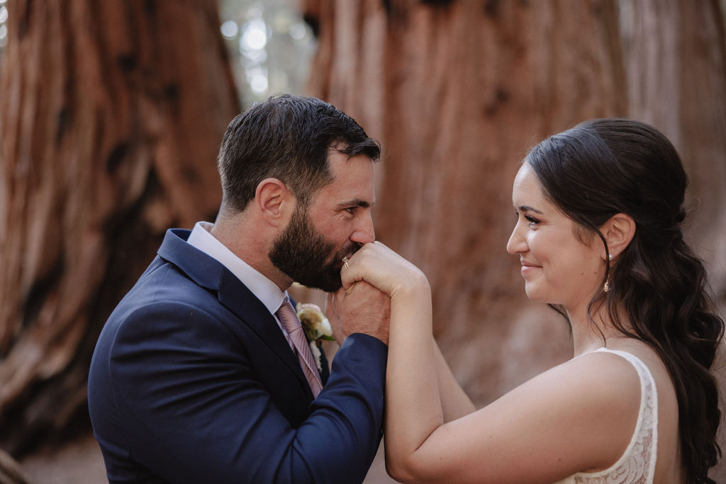 A bride in a white gown holds a bouquet while standing in front of large redwood trees 
Top 5 reasons to elope in sequoia national park