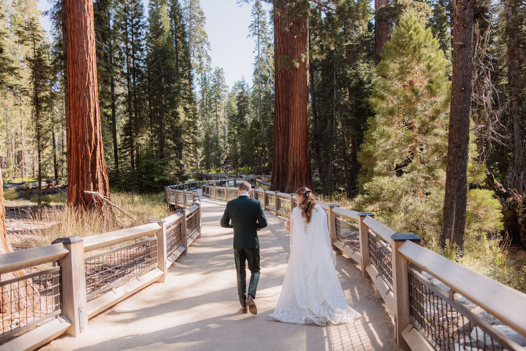 couple walking through mariposa grove at yosemite national park 