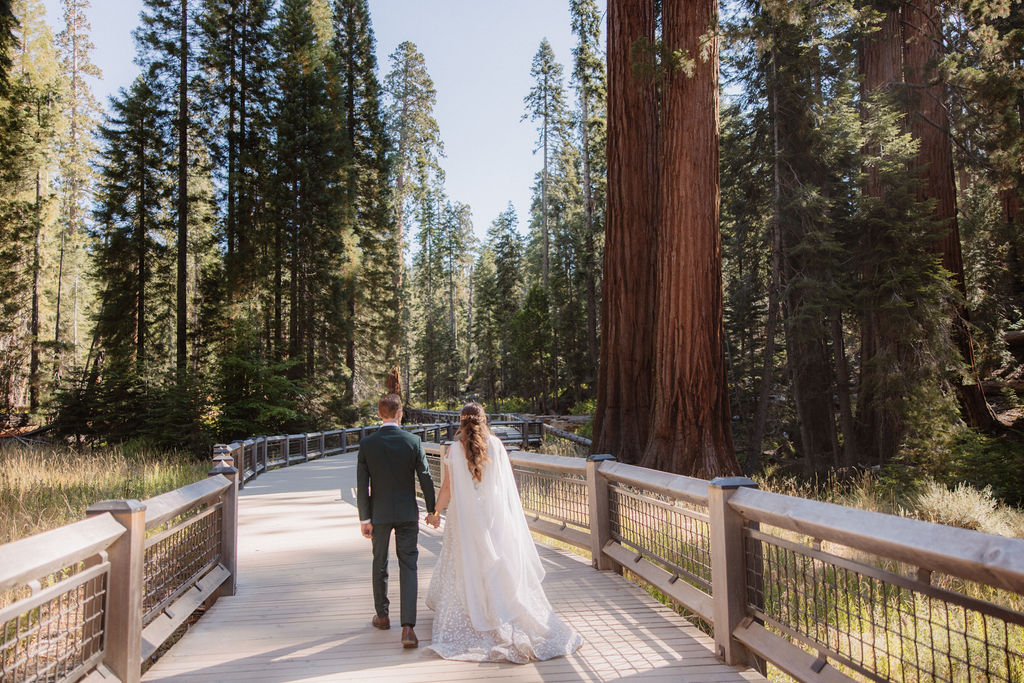 couple walking through mariposa grove at yosemite national park 