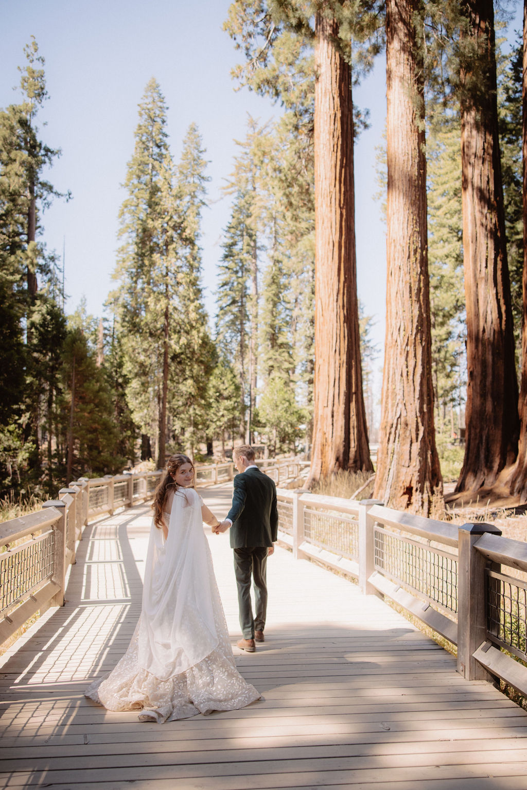 couple walking through mariposa grove at yosemite national park 