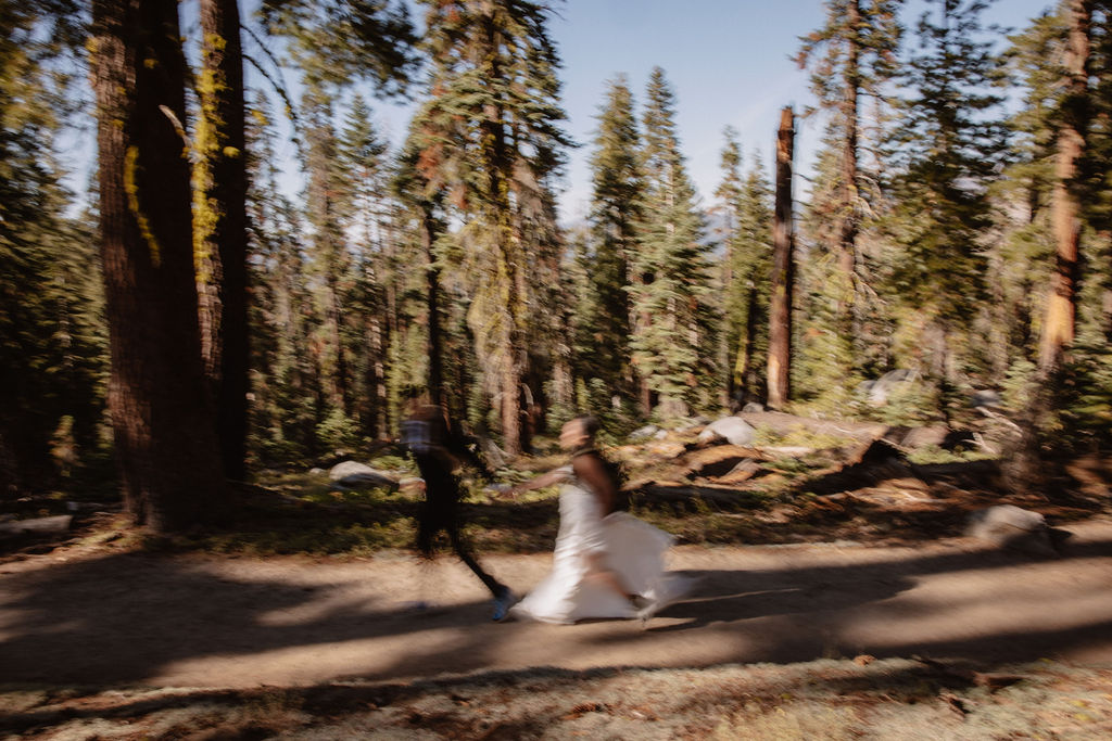  couple hiking through the woods during their yosemite elopement| best views at Yosemite National Park