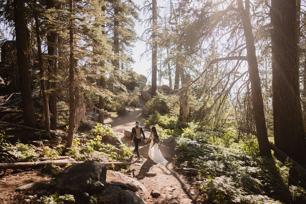 couple hiking through the woods during their yosemite elopement| best views at Yosemite National Park