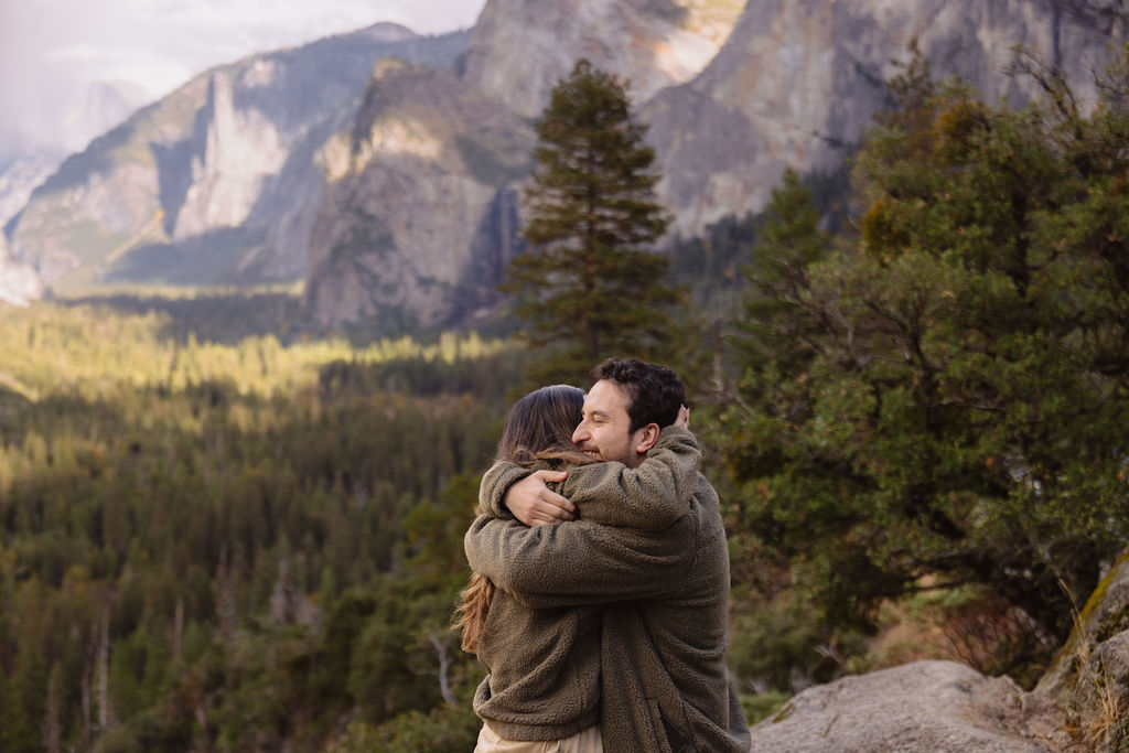 a couple takes photos at tunnel view after a proposal