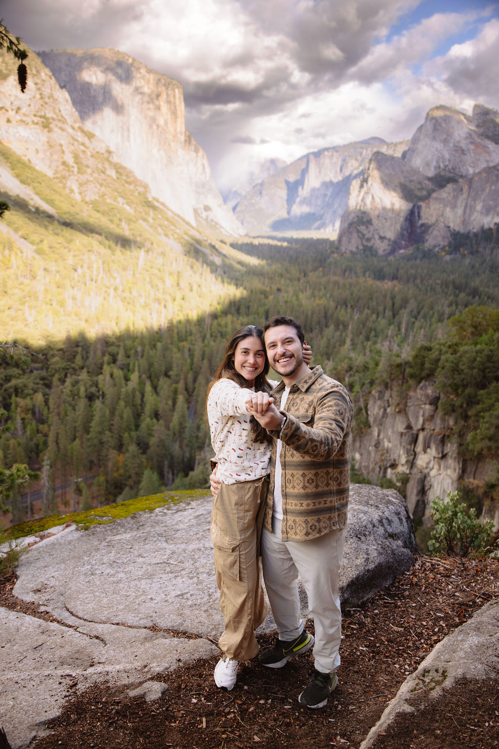 a couple takes photos at tunnel view after a proposal