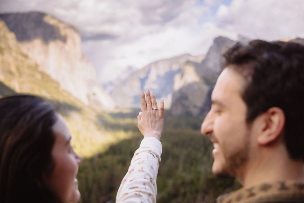 a couple takes photos at tunnel view after a proposal at yosemite national park